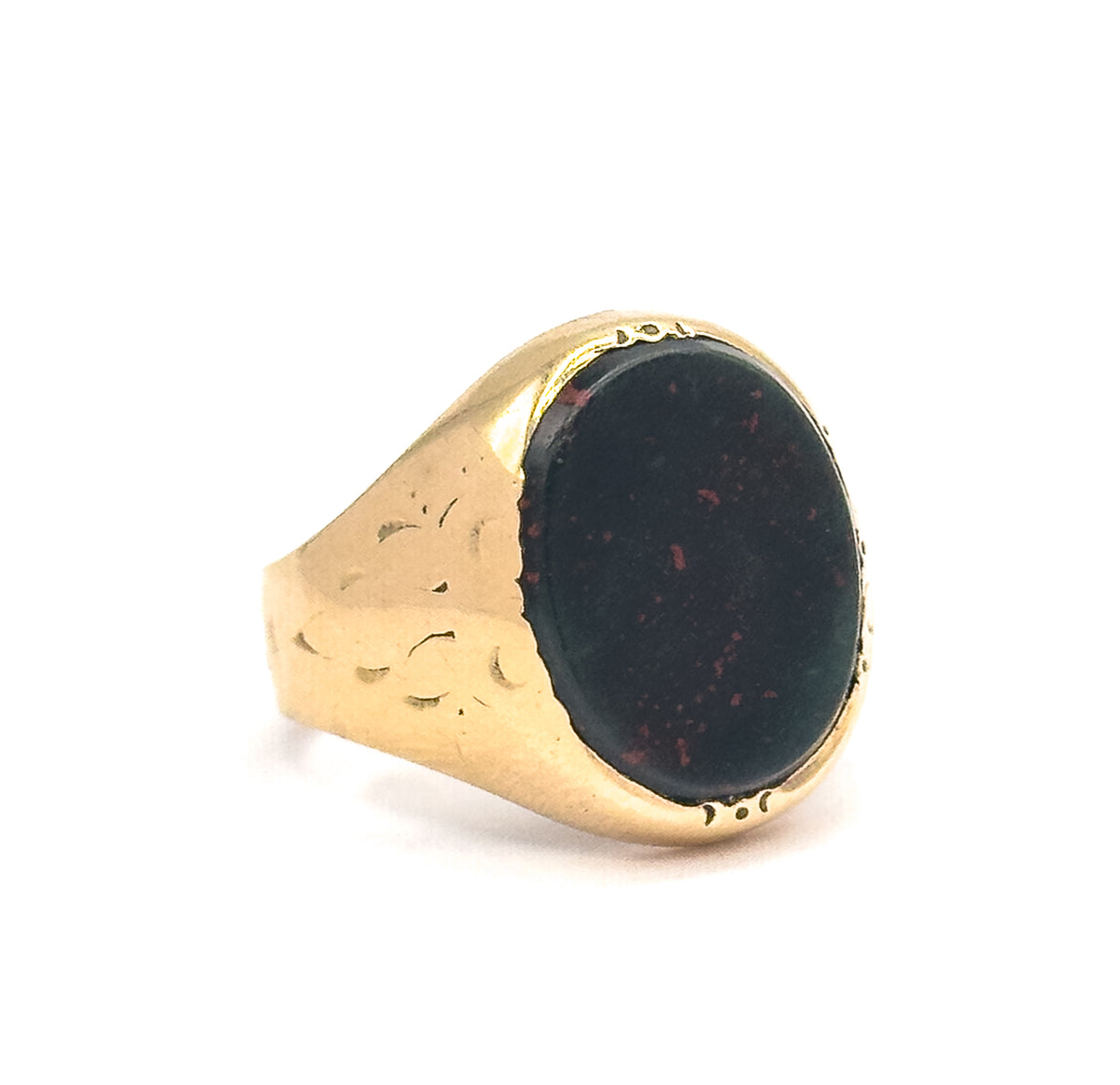 An Edwardian bloodstone signet ring in 14K yellow gold, shown upright at an angle, its dark green oval stone with red speckles set above engraved, tapered shoulders.