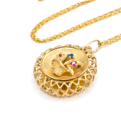 Angled three-quarter view on white showing the pendant's full depth, the domed lattice gallery curving round beneath the textured basket, with the chain coiled behind the bail.