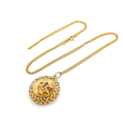 The whole necklace laid out flat on white in a long loop, the fine twisted chain and its spring ring clasp at the top, the round basket pendant hanging at the lower end.