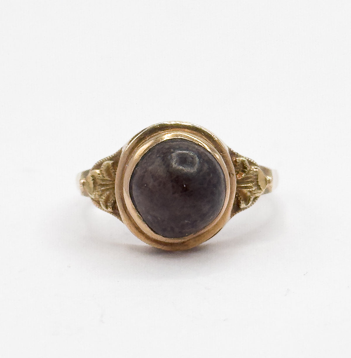 Almost the same view with slightly different angle, the round brown cabochon sitting slightly higher in its bezel while the leaf-like shoulder details and tapering shank show at each side.
