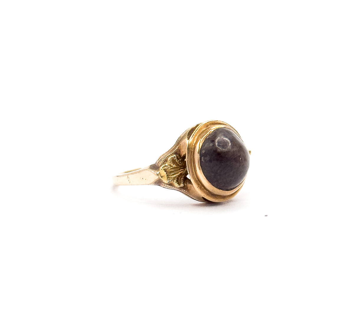 Side profile against white, showing how the elevated gallery lifts the domed brown cabochon above the decorative shoulders, which taper down into the slim shank.
