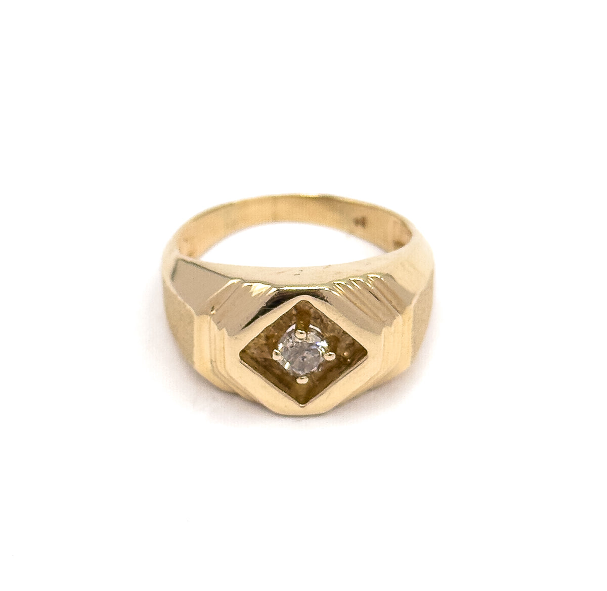 Tipped slightly forward so the top of the band curves away behind the face, the recessed diamond-shaped panel and its prong-set round diamond sit low against the yellow gold shoulders.