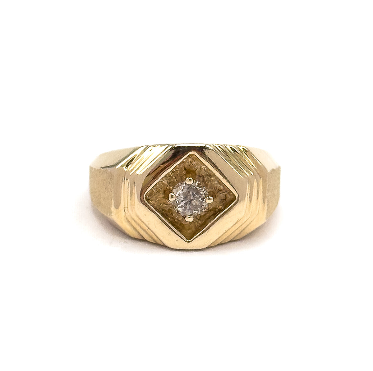 A close frontal crop that fills the frame with the face, bringing out the matte texture inside the recessed diamond-shaped panel and the four separate prongs gripping the round diamond.