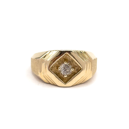 A close frontal crop that fills the frame with the face, bringing out the matte texture inside the recessed diamond-shaped panel and the four separate prongs gripping the round diamond.