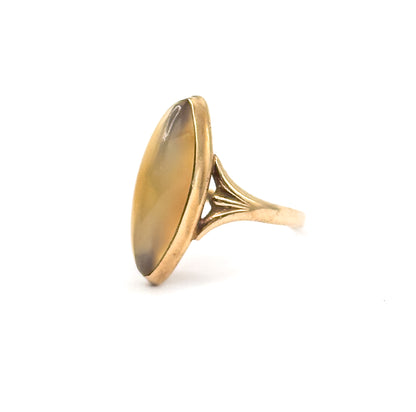 Angled from the opposite side against white, the long navette face turns nearly edge-on so the bezel rim, the ribbed fan of the shoulder and the taper of the shank run away to the right.
