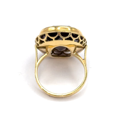 Viewed from behind and below, the open back of the setting reveals the underside of the smoky quartz through the scalloped gallery arches, with the slim yellow gold shank forming a full circle.