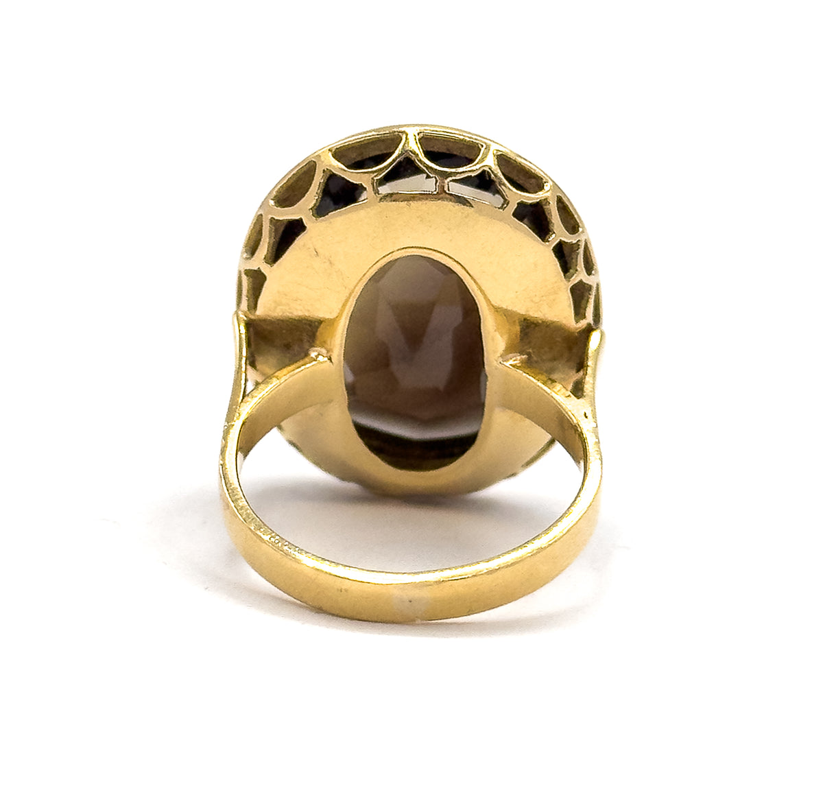 Straight on from the back, a large oval opening in the yellow gold plate frames the underside of the smoky quartz, ringed above by scalloped cut-outs, with the shank looping below.