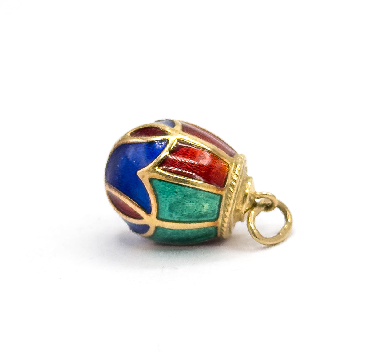 The charm lies on its side against white, showing the green and red panels across the body, the rope-textured collar and the open round bail to the right.