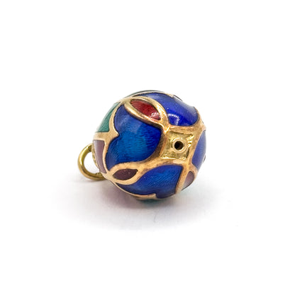 Tilted to show the domed end of the egg, where gold ribs cross around a small round opening, with blue panels edged in red and green and the bail curving out at the left.