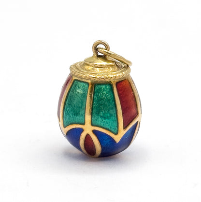 Closer upright view filling the frame, where the brushed shimmer within each green, red and blue enamel panel shows between the fine gold outlines, the rope-edged collar and open bail above.