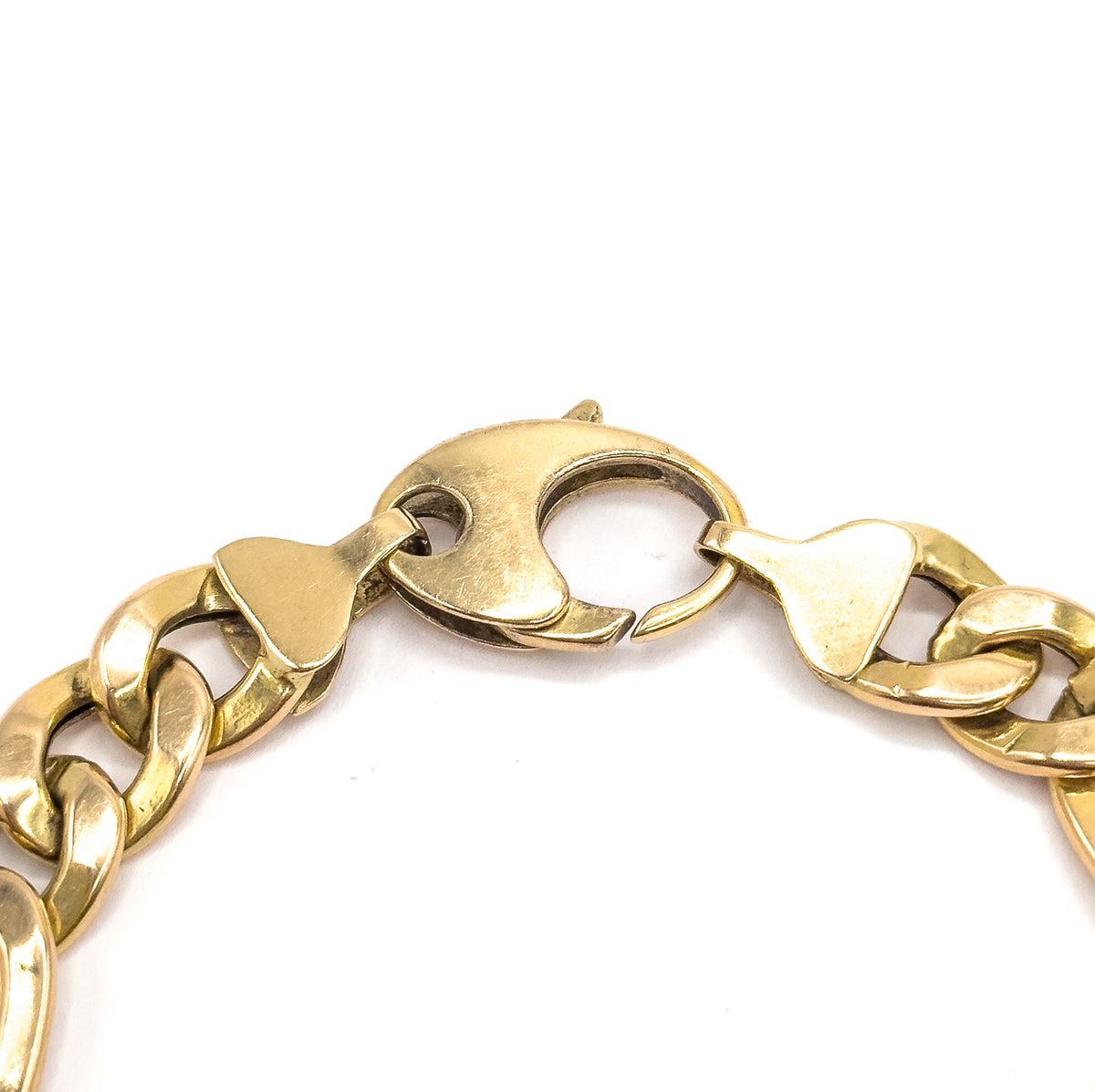 A close view of the jumbo lobster clasp itself, its broad curved yellow gold body with the thumb-piece at top, flanked by the flat tapered end links it joins.
