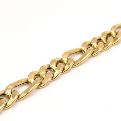 A close diagonal view of the yellow gold links alone on a white background, showing the flat faceted edges of the short links beside the elongated ones.