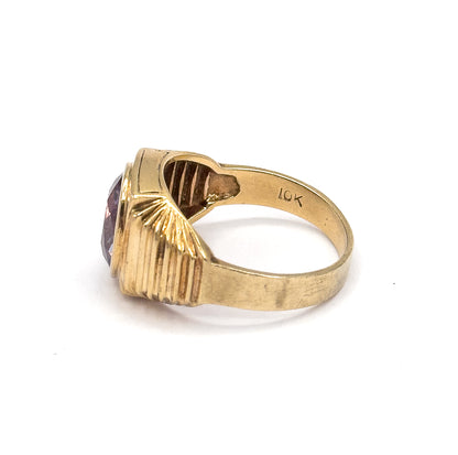 Angled from the back of the shank, the inside of the yellow gold band shows a small stamp, with the fan-like ridges of the shoulder flaring toward the bezel's rim at left.