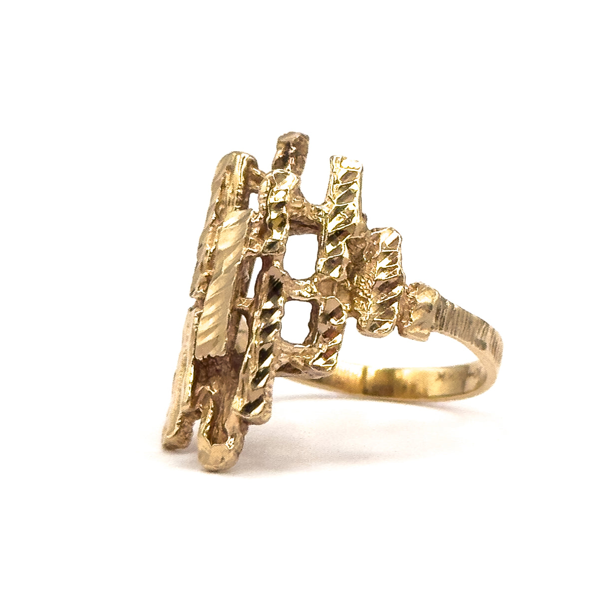 Angled from the end of the head, the faceted yellow gold bars step down in staggered tiers toward the textured shank, showing the ring's full length front to back.