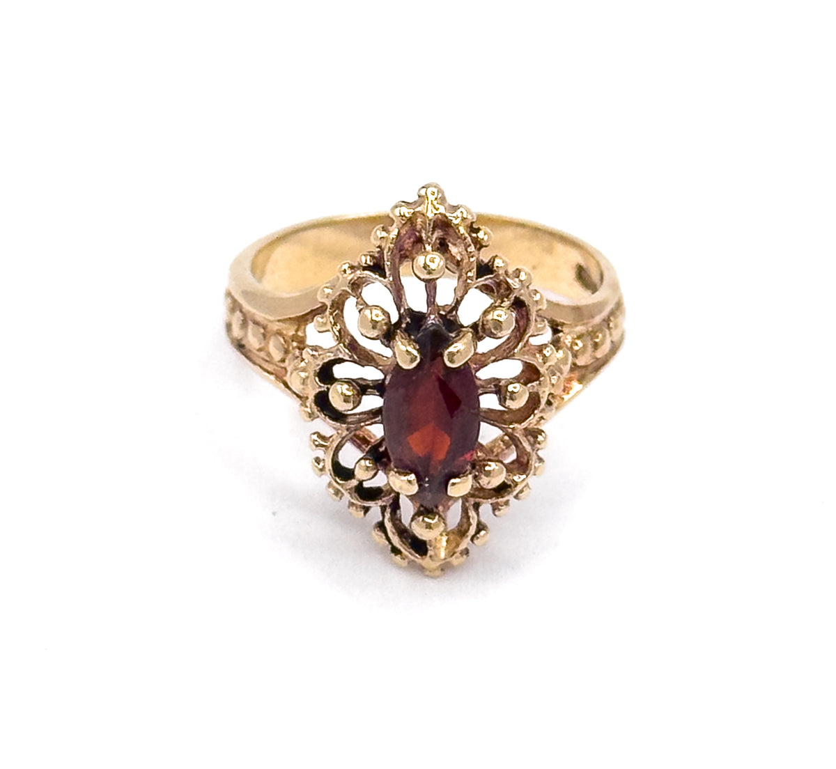 Looking straight down on the navette face, the marquise garnet sits upright at the centre within scrolled openwork and clustered beads, the shank tapering away to either side.