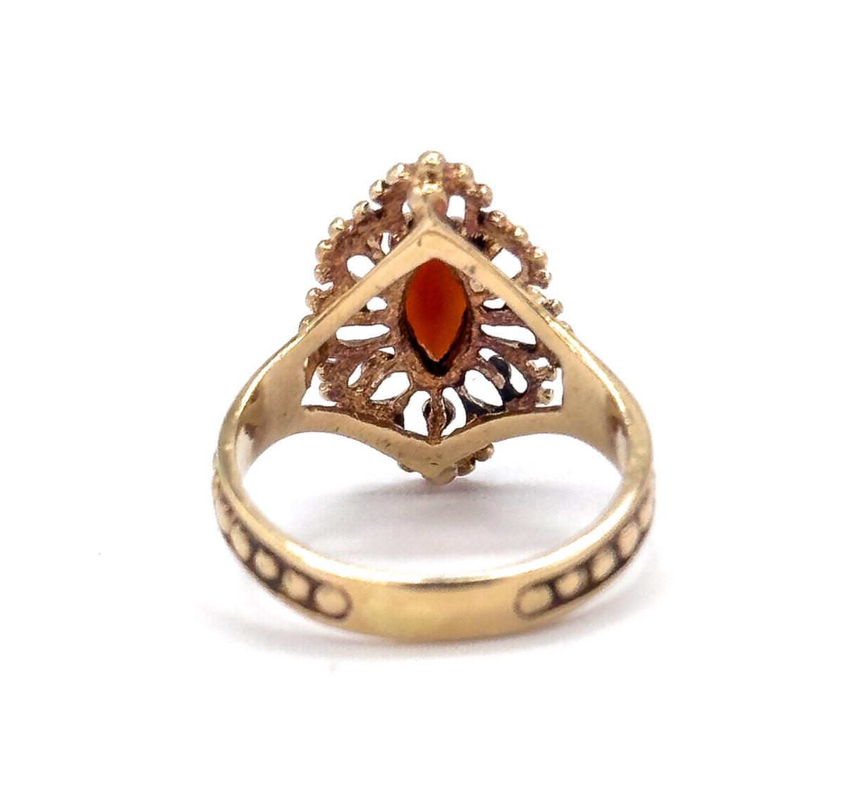 The underside of the navette face, open gallery pierced with scrolled cut-outs revealing the back of the marquise garnet, with the beaded shank sweeping below.