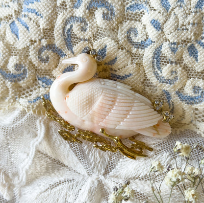 A closer, slightly turned view showing the swan's raised neck and beak, the small diamond cluster above its head, and the finely carved feather rows sweeping back over the body.