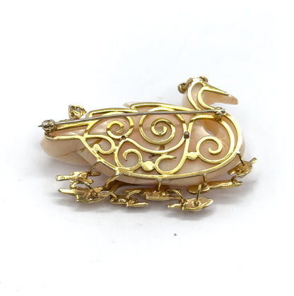 The full reverse against a plain white background, with the swirling openwork gallery, the pin stem crossing from hinge to catch, and the gold reeds splaying out below.