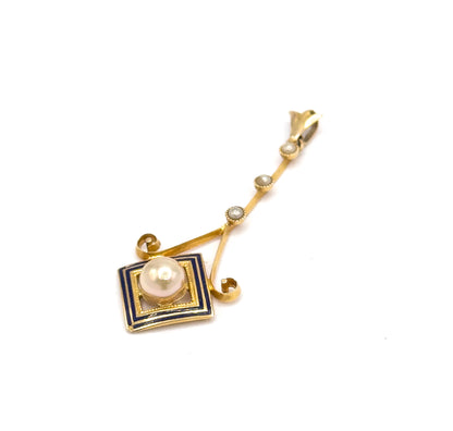 Laid on plain white at a steep diagonal with the bail's loop at the top right, the whole length visible from the three seed pearls down to the cobalt blue enamel square and its creamy pearl.