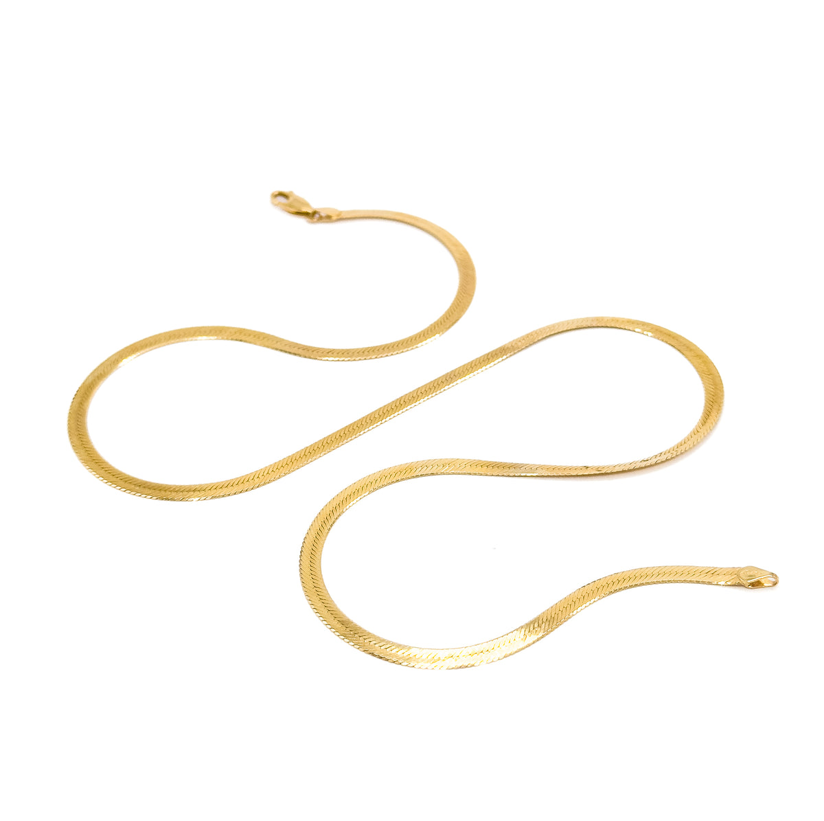 The full chain laid out flat on white in a long S-curve, showing its whole length at once with the lobster clasp at one end and the flat ring fitting at the other.