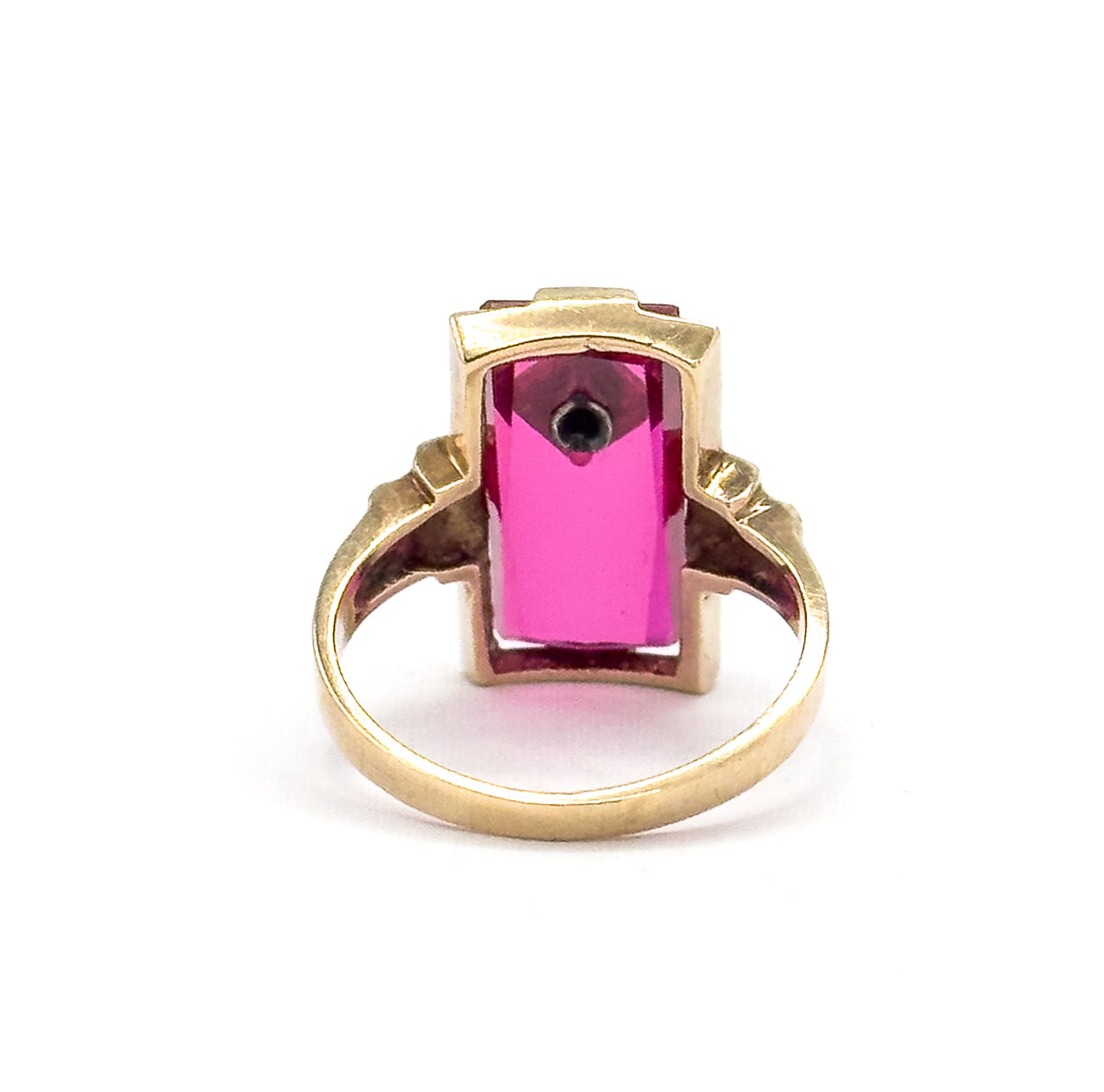 Almost the same view with slightly different angle, straight through the back of the setting, where the long stone glows bright pink and the small diamond's dark point shows at the upper end.