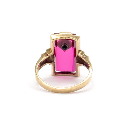 Almost the same view with slightly different angle, straight through the back of the setting, where the long stone glows bright pink and the small diamond's dark point shows at the upper end.