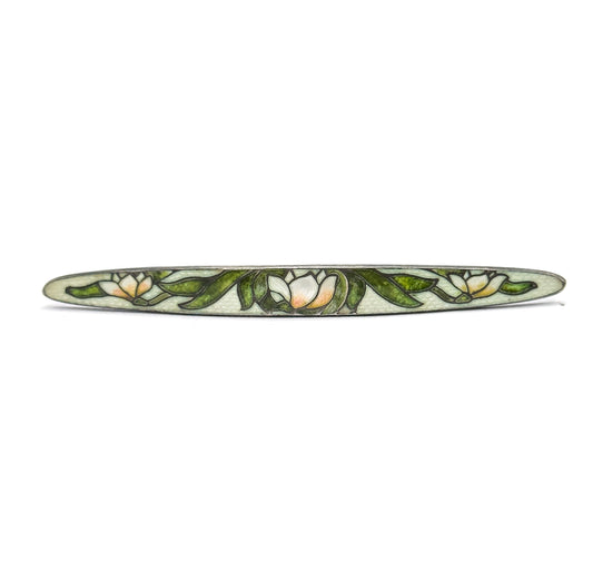 The whole brooch square-on against white, its long tapered bar showing all three white blossoms evenly spaced among green leaves from pointed tip to pointed tip.