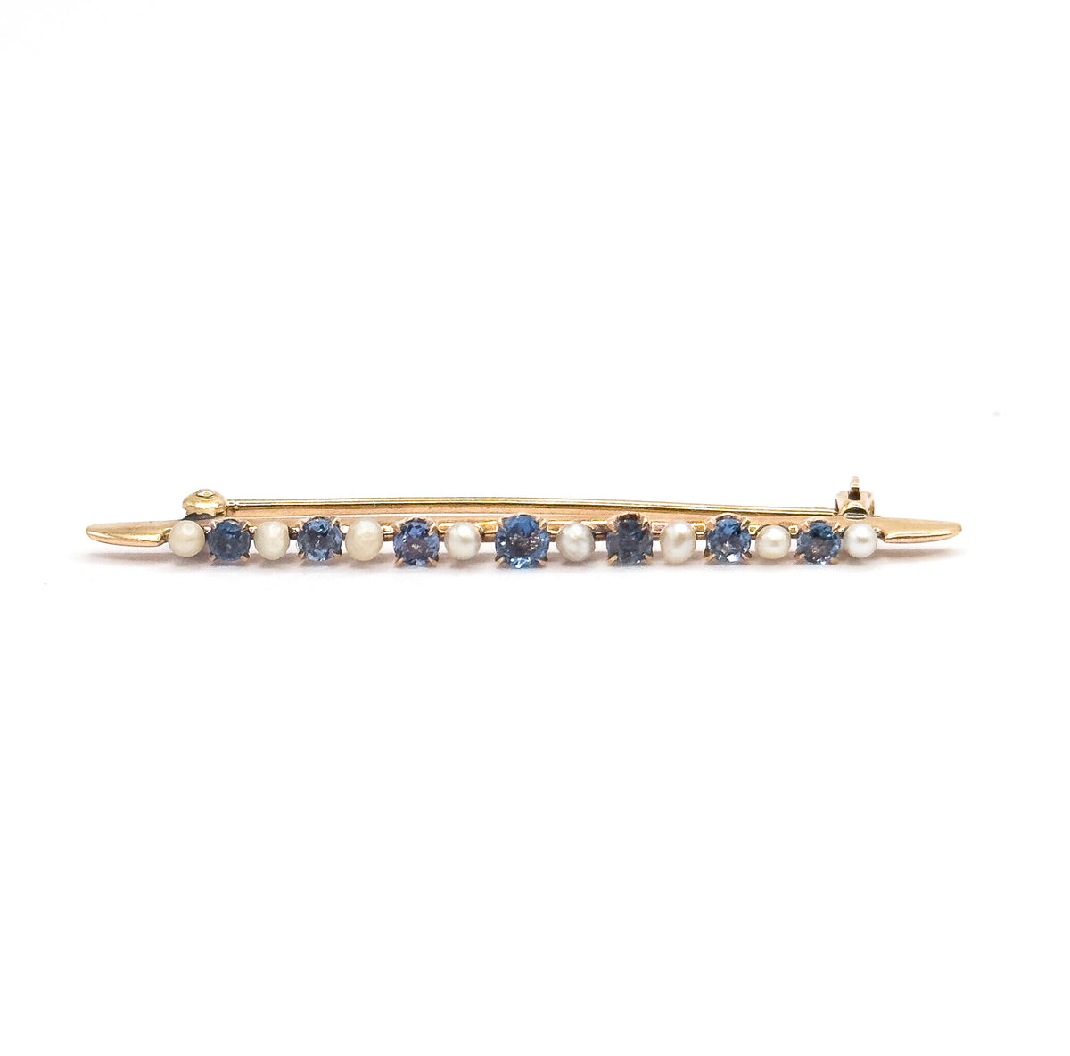 Straight-on full-length front view with the bar lying level and the pin stem closed behind it, hinge at the left and catch at the right, the alternating sapphires and seed pearls in one even row.