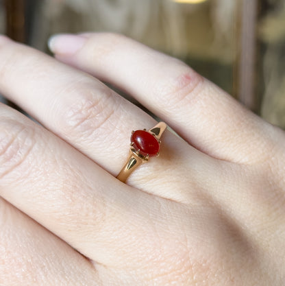 Almost the same view with slightly different angle, closer in on the ring finger so the prongs gripping the oval cabochon and the tapering shoulders catch the light.