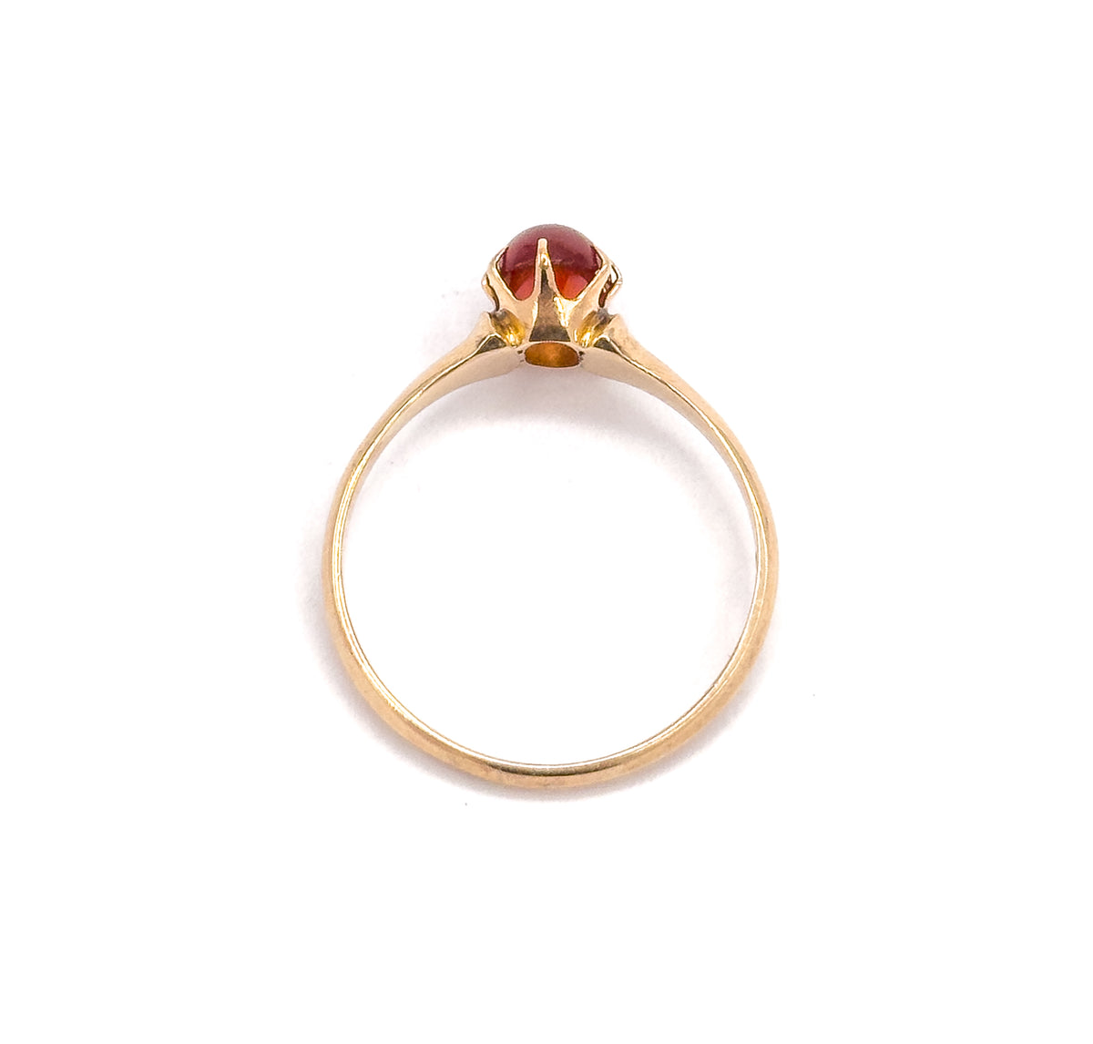 Upright head-on view through the circle of the slim shank, the oval orange cabochon sitting in its pronged setting at the top with an open gallery beneath.