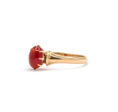 Low side-on view with the cabochon at the left, the ridged shoulder stepping down into the smooth yellow gold shank that sweeps away to the right.