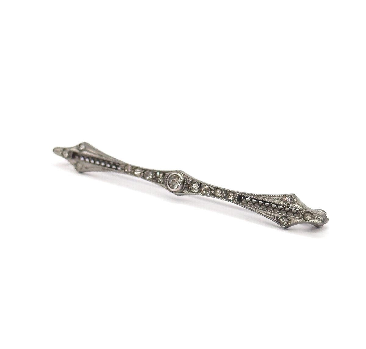 Steeply foreshortened view along the length of the bar, the near point closest to the camera so the slim depth of the filigree frame and the raised central bezel stand out.
