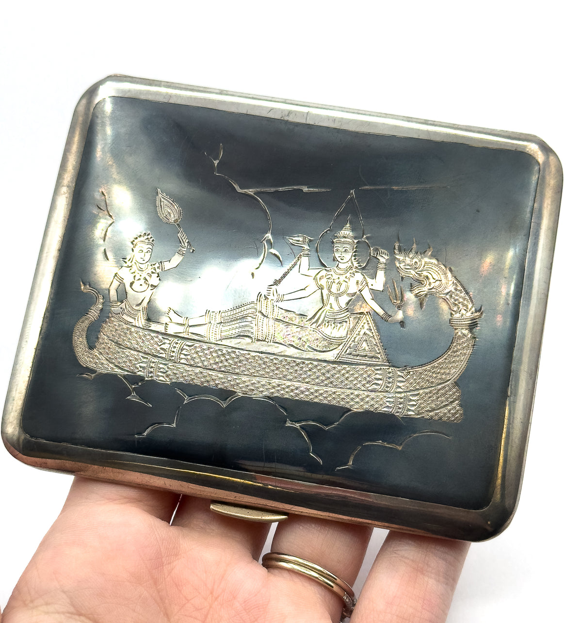 Held flat on an open palm so its size fills the hand, the whole rectangular case is in view with rounded corners and a small clasp thumbpiece at the lower edge.