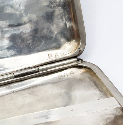 Opened interior corner showing the hinge barrel running between the two halves, each stamped 888 on its polished light-metal rim.
