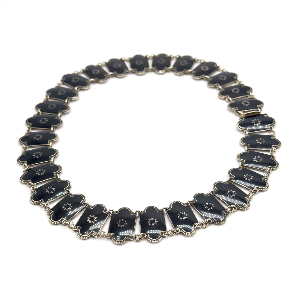 The full necklace laid flat in a complete circle on white, showing every enamel station around the loop and the clasp fitting at the right-hand side.