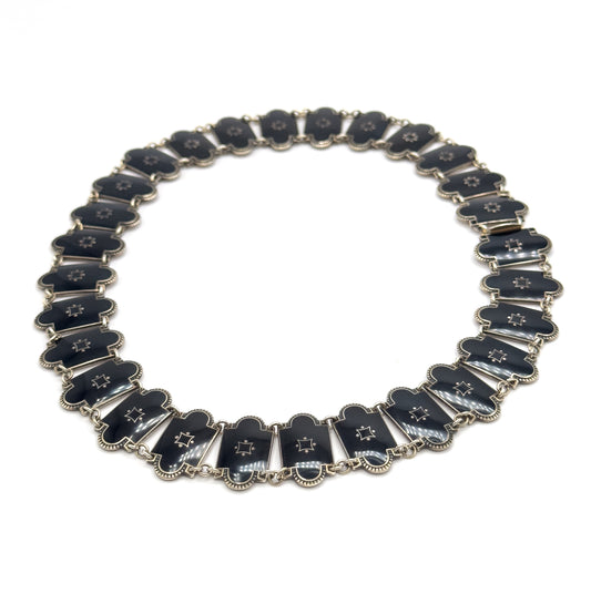 The full necklace laid flat in a complete circle on white, showing every enamel station around the loop and the clasp fitting at the right-hand side.