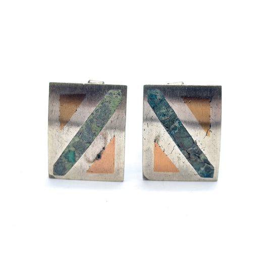 Vintage Mexican Taxco sterling silver cufflinks with turquoise inlay, the pair standing face-on against white, each rectangular face crossed by a diagonal stone band with peach-toned triangles.
