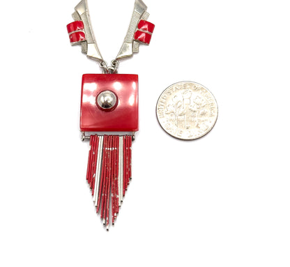 Shown beside a ten-cent coin for scale, the red square plaque stands a little taller than the coin, with its fringe rods and the shoulder links and red bars above it.