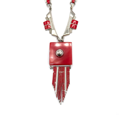Straight-on close view with both sides of the chain symmetrical at the top, the red square plaque and its domed stud centred, and the alternating red and light-coloured fringe rods tapering to a point.