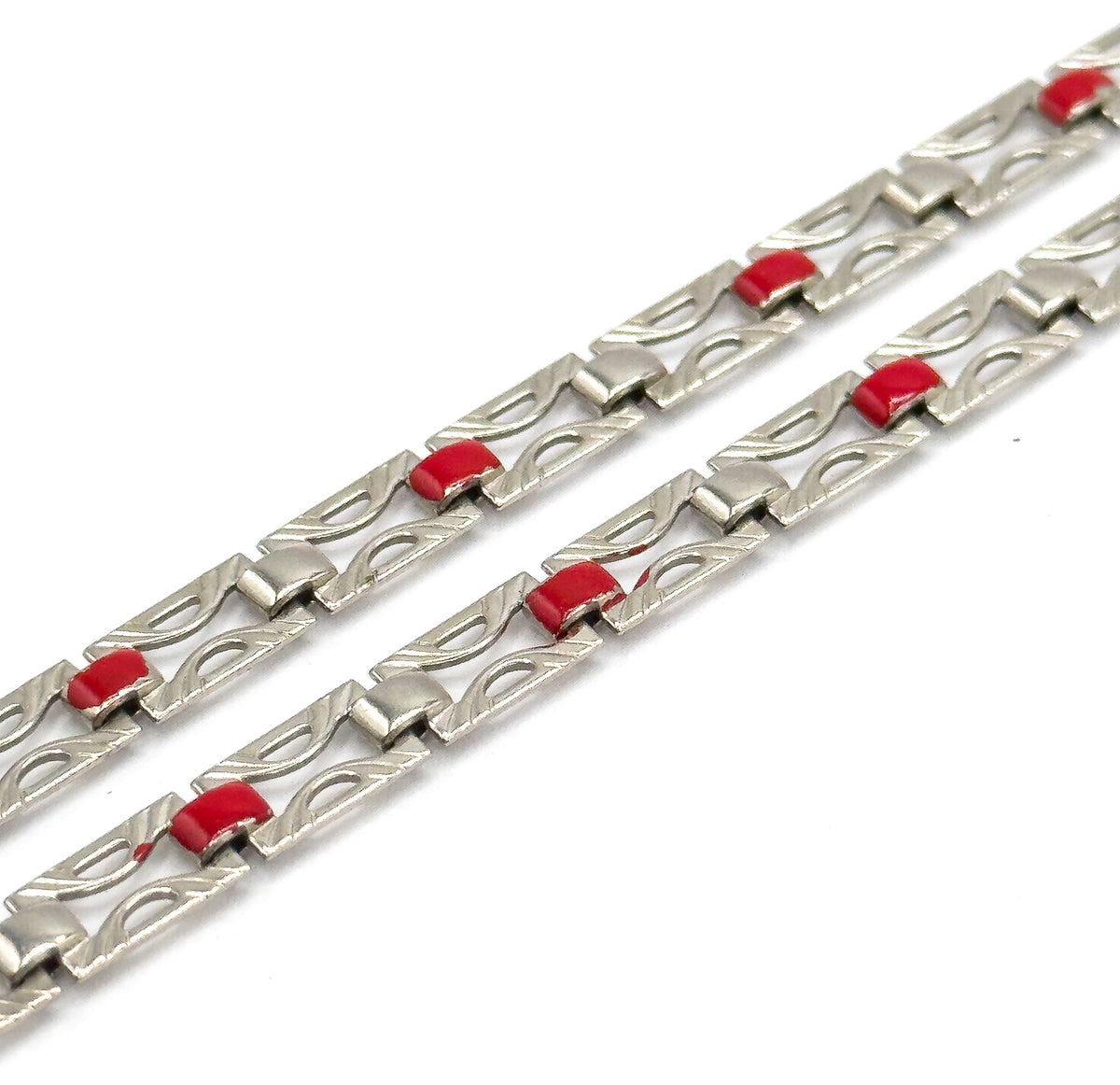 Two runs of chain recede steeply into the distance against white, each pierced link's engraved outline and small squared connector sharp in front and softening away toward the top.