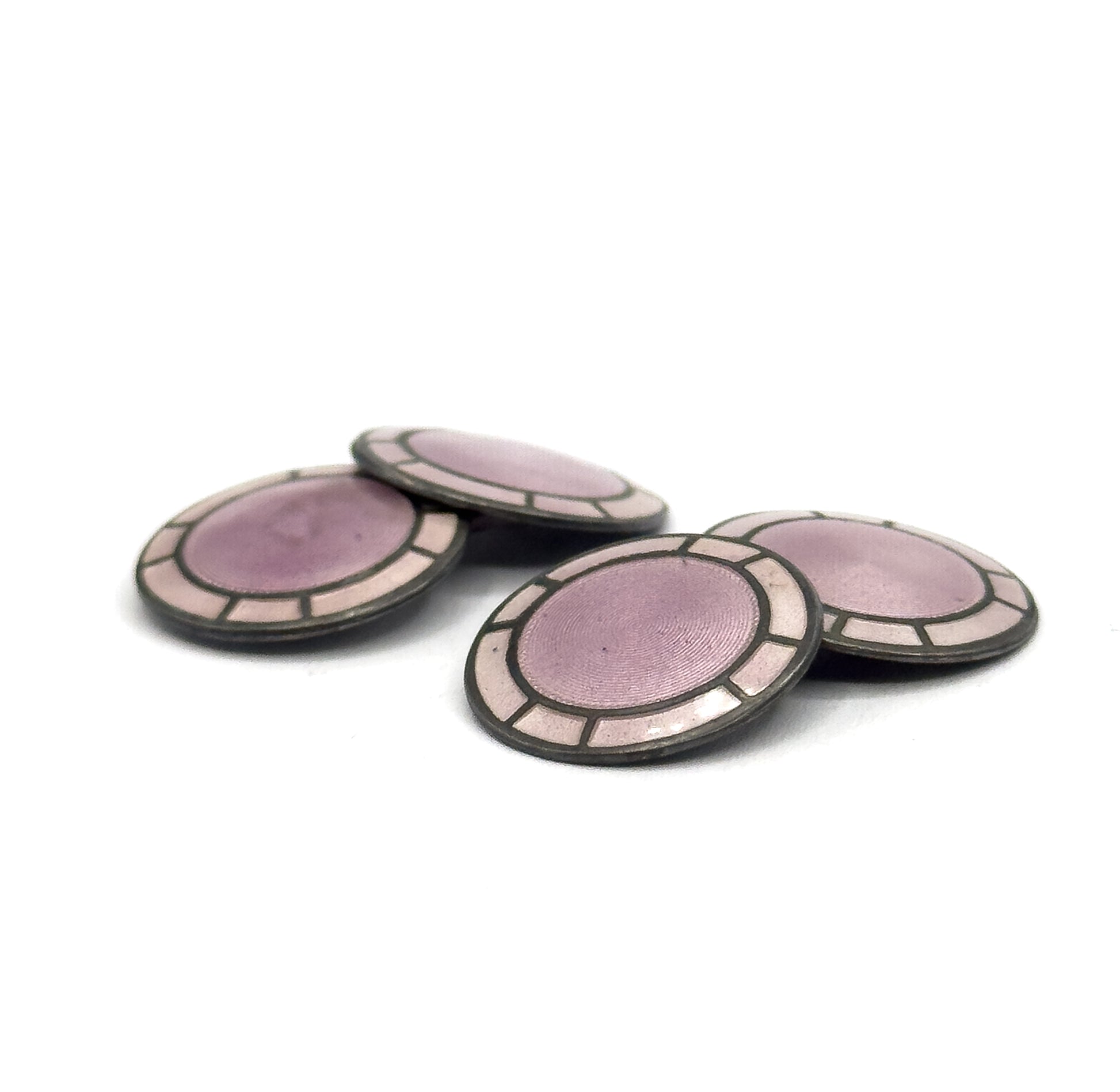 All four circular discs lie angled on a white surface, showing the lavender guilloche centres ringed by pale enamel panels within darker silver rims.