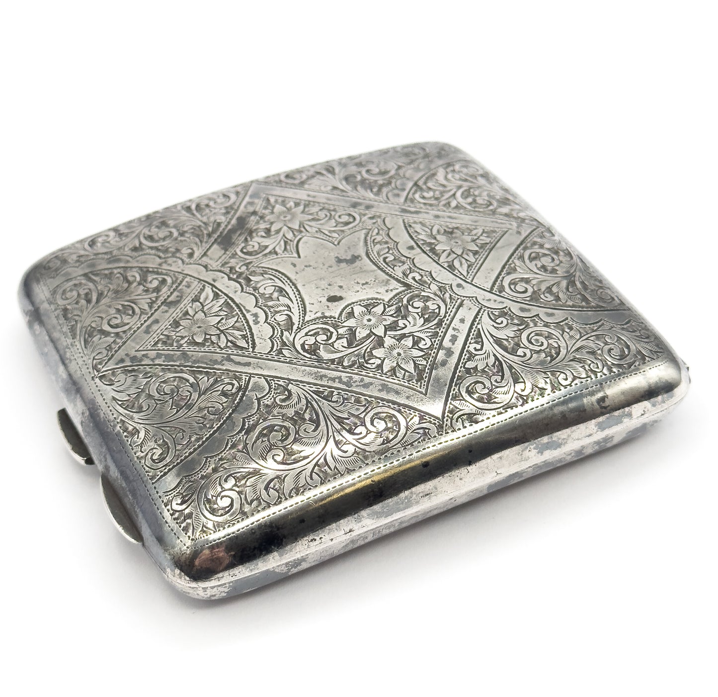 The case tilted forward to show its depth and the plain polished side wall below the engraved lid, with darker patina gathered along the seam.