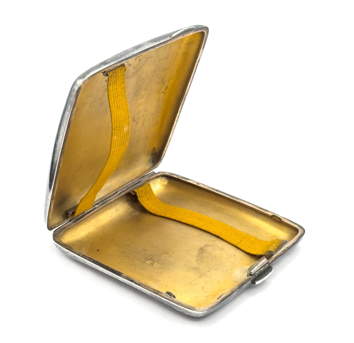 The case standing open, showing both gilt interior halves and the yellow woven straps that hold cigarettes in place.