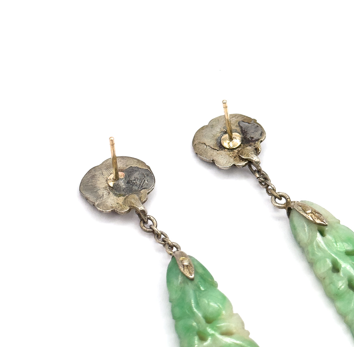 Almost the same view with slightly different angle, cropped closer on the scalloped backs of the two tops so the bare posts, small backs and the chain links meeting the jade drop tips fill the frame.
