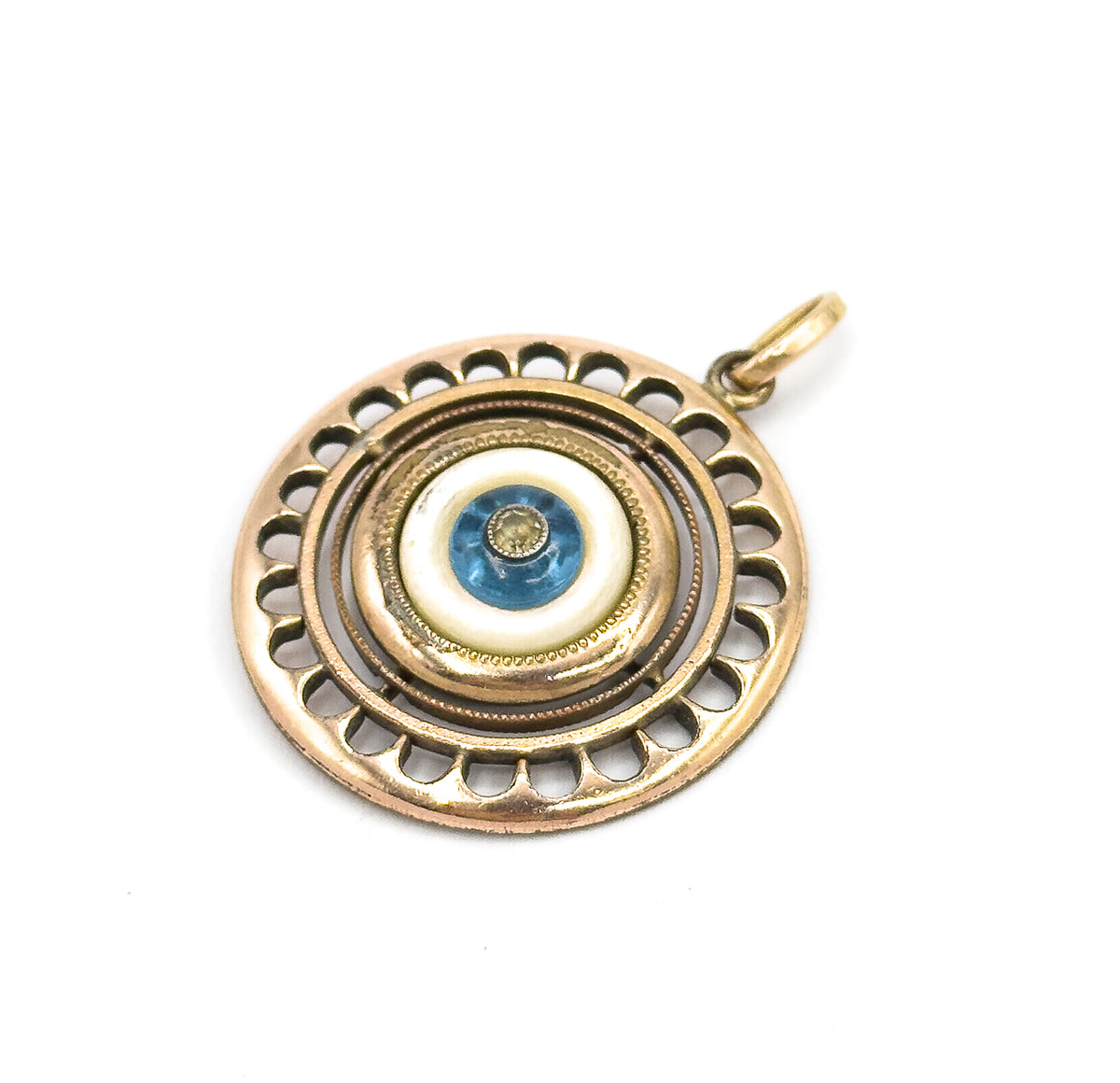 The pendant tilted face-up on a white background, the scalloped openwork rim and milgrain rings catching light as the bail angles to the upper right.
