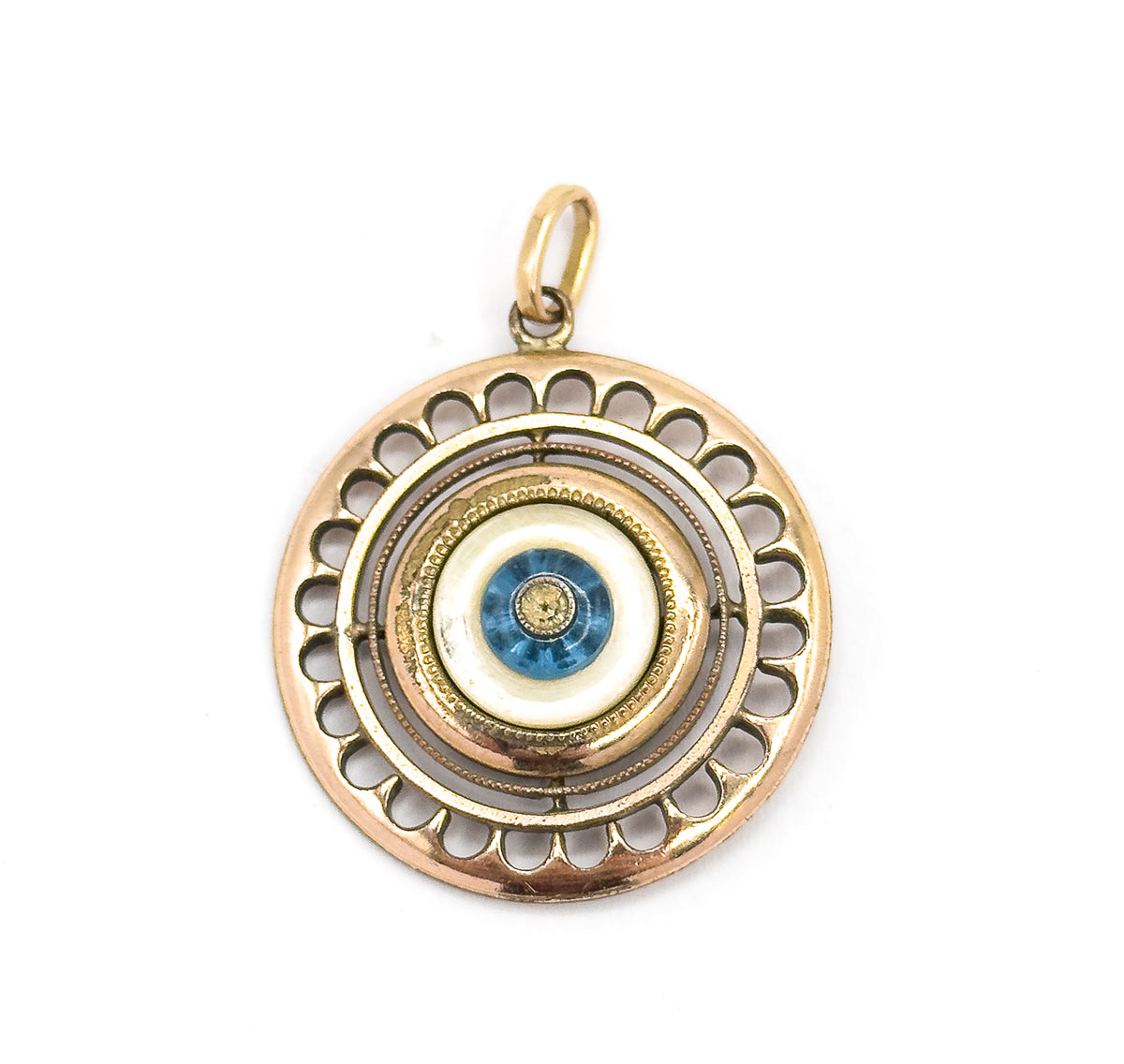 Close in on the centre with the bail upright at top, showing the tiny colourless paste stone bezel-set within the blue glass bead, ringed by mother of pearl and beaded milgrain bands.