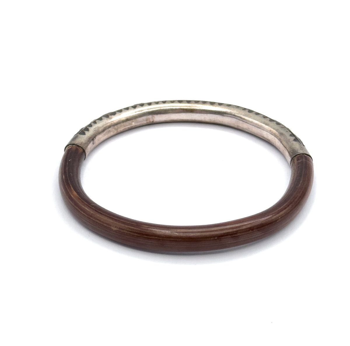 Looking down into the open circle of the bangle, with the silver section set at the far side so both joins where metal meets wood are visible against the rounded band.