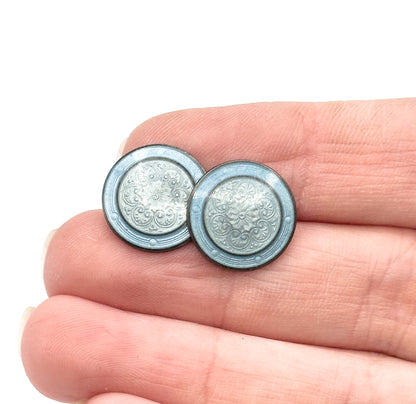 Vintage guilloche enamel cufflinks in sterling silver, the two round discs resting on fingertips to show their small size, each face swirled with grayish and dusty blue enamel.