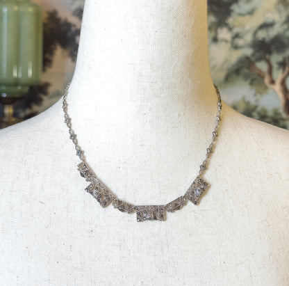 Closer frontal view showing the five graduated rectangular front panels set with small grey marcasites in milgrain-edged metalwork, the slim chain rising evenly on both sides toward the nape.