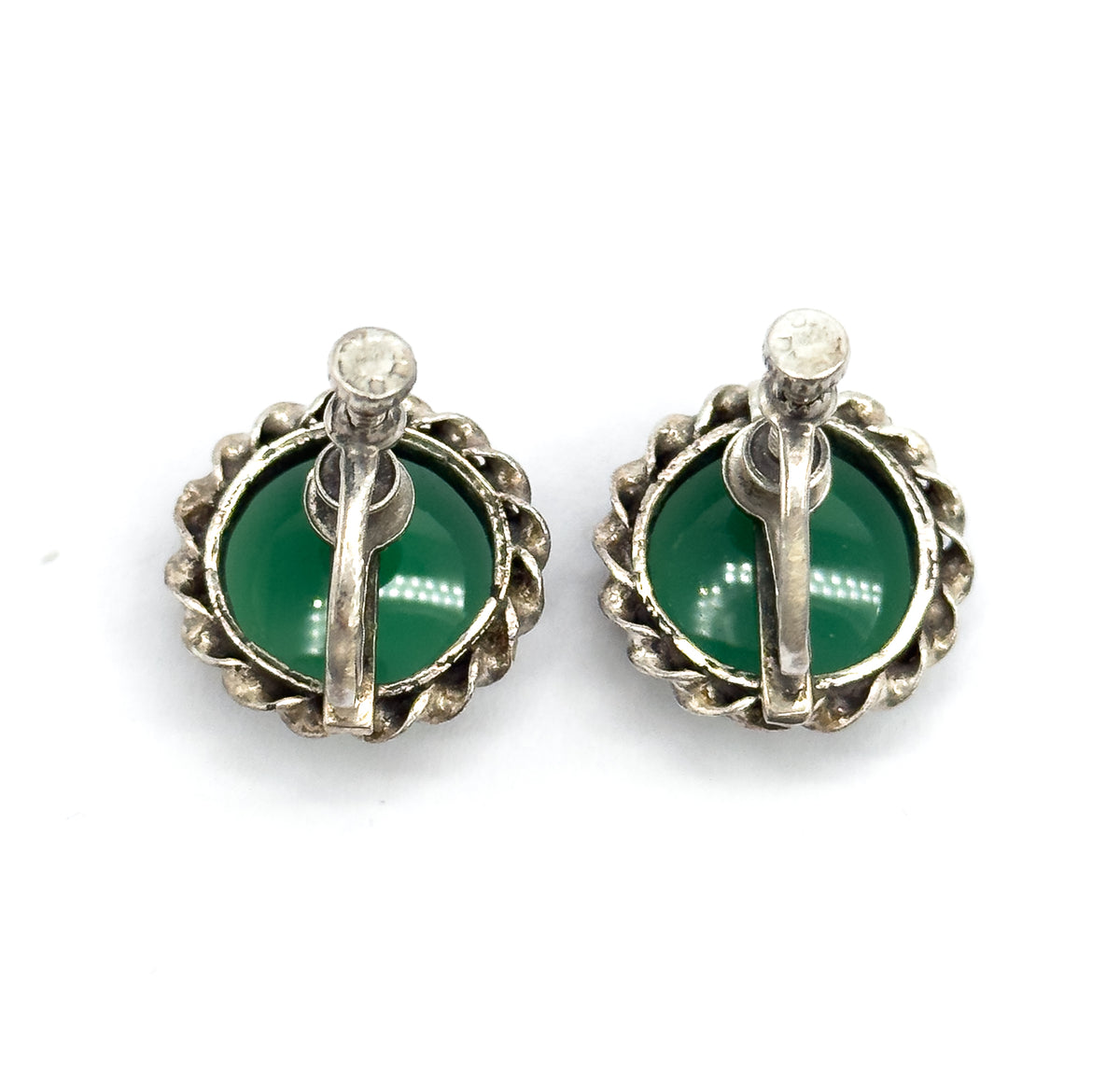 Reverse view of the pair, the screw-back bars and round screw heads crossing each green cabochon inside its cable-textured sterling silver frame.